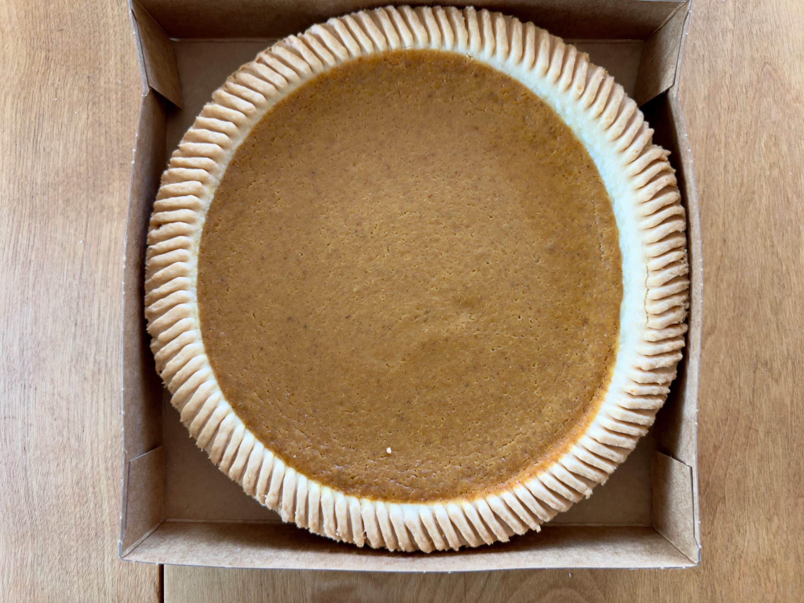 Trader Joe's Pumpkin Pie sitting in the box, uncut
