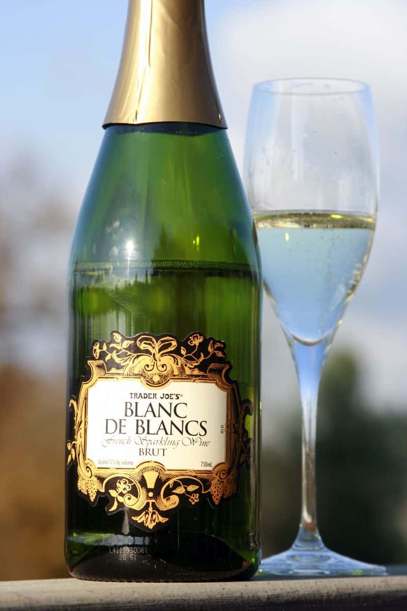 Bottle of Trader Joe's Blanc de Blancs Brut French sparkling wine next to a filled champagne flute