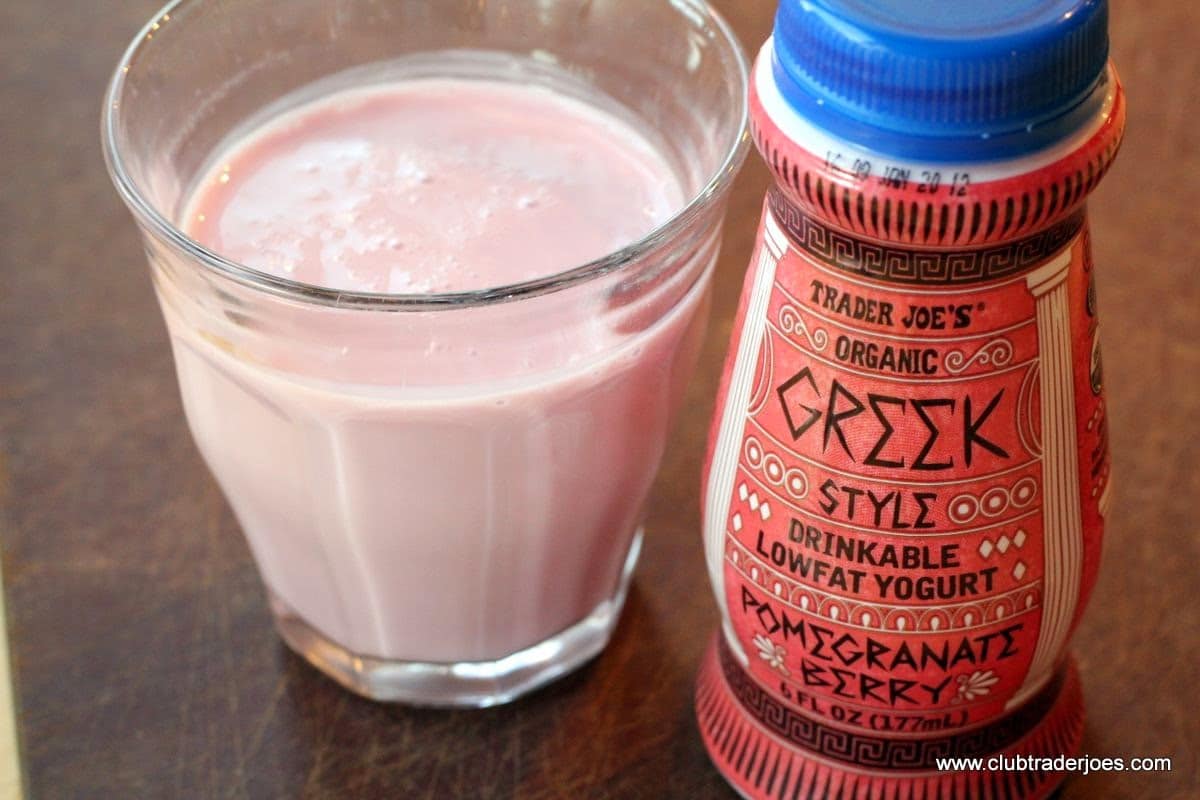 Bottle of Trader Joe's Organic Greek Style Drinkable Lowfat Yogurt, Pomegranate Berry, next to a full glass
