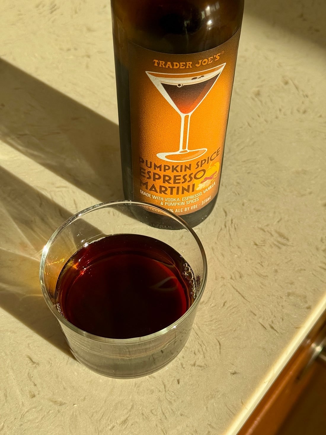 Bottle of Trader Joe's Pumpkin Spice Espresso Martini next to a poured glass